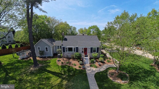 view of front of home featuring a chimney, fence, and a front yard