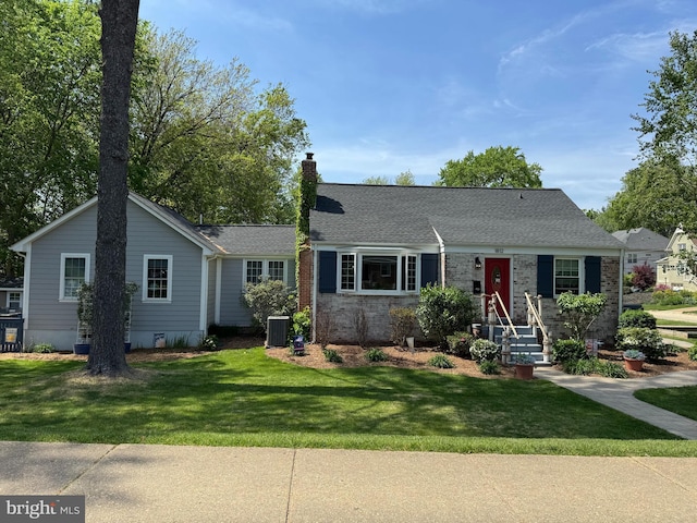 view of front of home featuring a chimney, cooling unit, and a front lawn