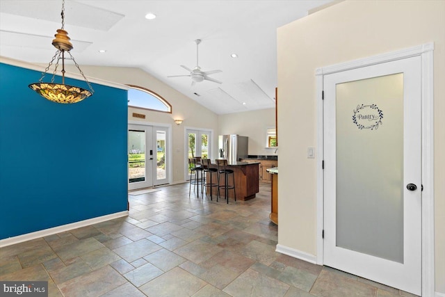 foyer entrance with a ceiling fan, vaulted ceiling, baseboards, recessed lighting, and stone tile floors