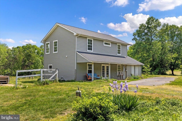 rear view of property with a lawn, roof with shingles, and french doors