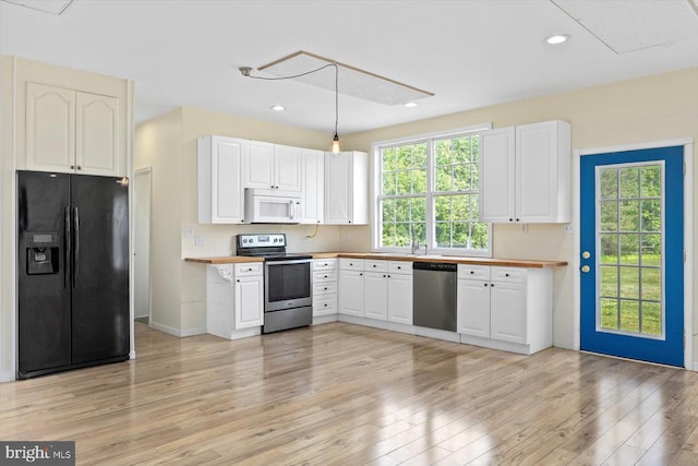 kitchen with recessed lighting, stainless steel appliances, light wood finished floors, and white cabinetry