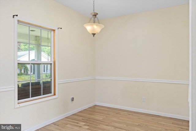 unfurnished room with baseboards and wood finished floors