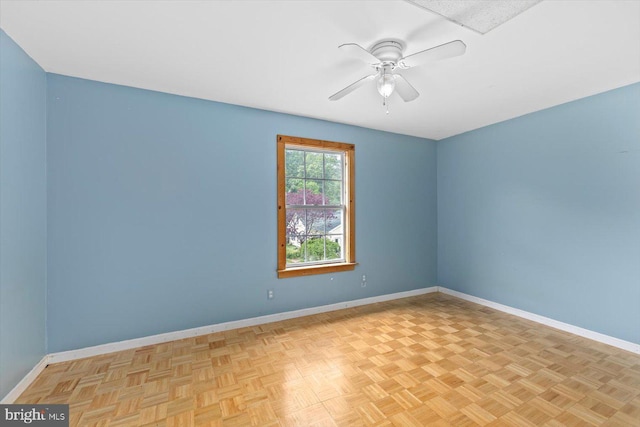 unfurnished room featuring ceiling fan and baseboards