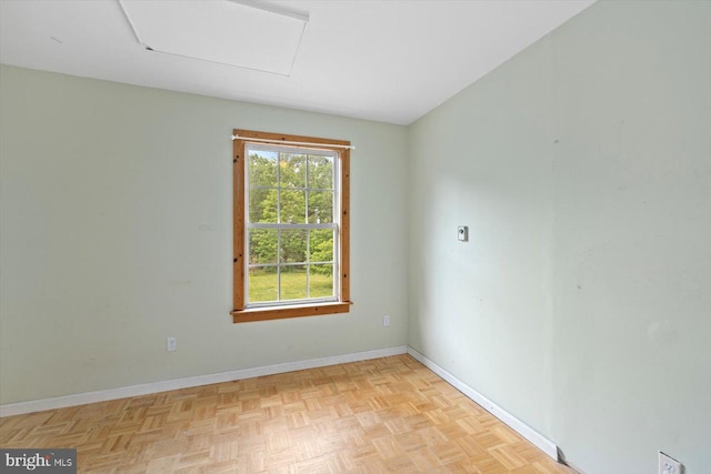 unfurnished room with baseboards and attic access