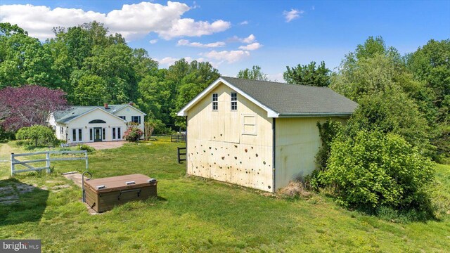view of outdoor structure with fence and an outbuilding