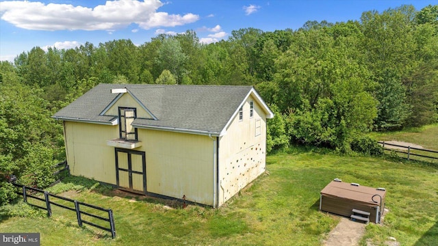 view of outbuilding with fence and a wooded view