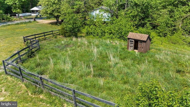 view of yard with fence, an outbuilding, and a storage shed