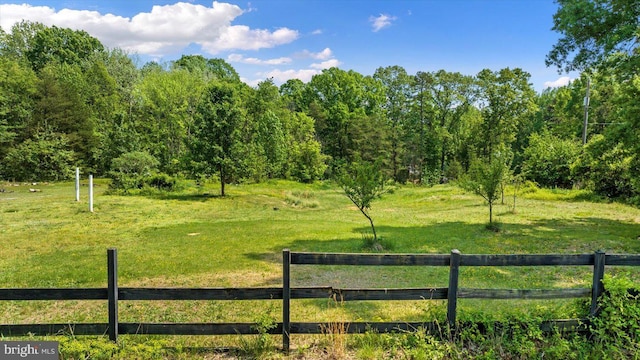 view of gate with fence and a lawn