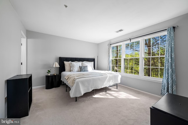 carpeted bedroom featuring baseboards and visible vents