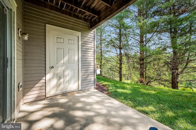view of exterior entry featuring a patio area and a yard
