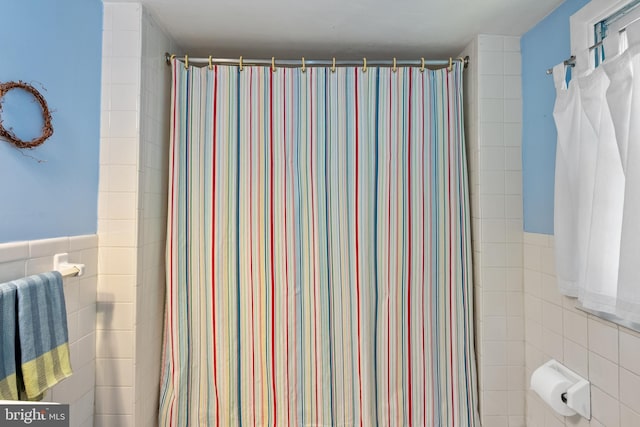 bathroom featuring tile walls and wainscoting