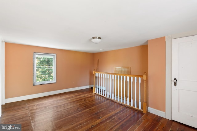 spare room featuring baseboards and wood-type flooring