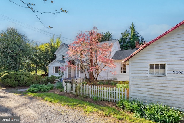 view of side of home featuring fence and roof with shingles