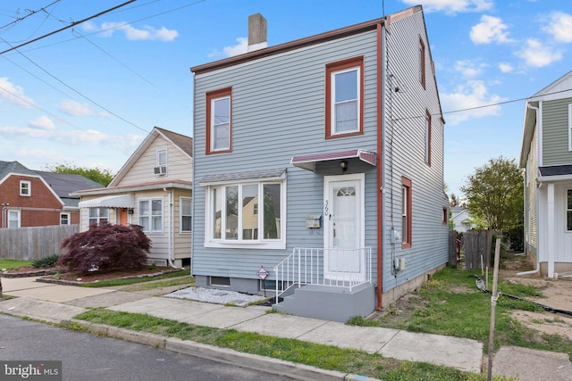view of front of home featuring fence and a chimney