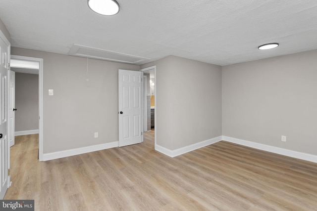 interior space featuring baseboards, attic access, and light wood-type flooring