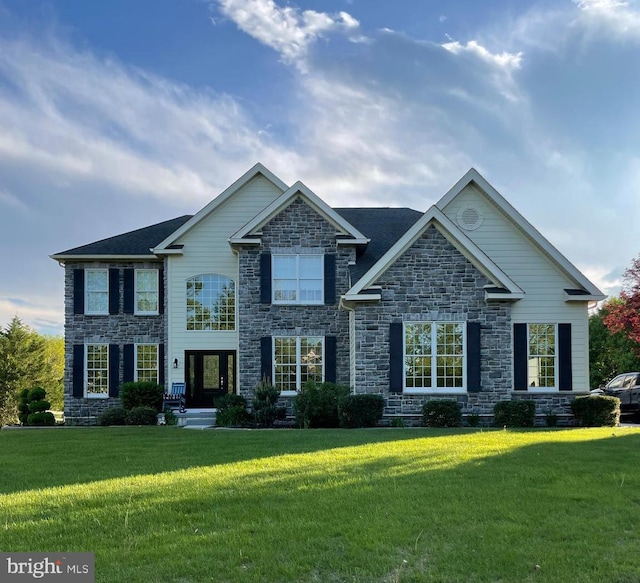 view of front of property with a front yard and stone siding