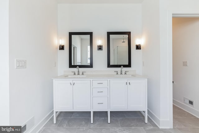 bathroom with visible vents, a sink, marble finish floor, and baseboards