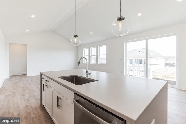 kitchen featuring stainless steel dishwasher, pendant lighting, white cabinetry, a sink, and vaulted ceiling