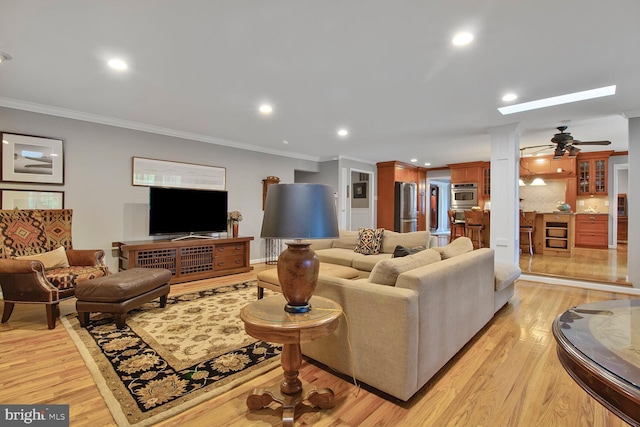 living area featuring light wood-style flooring, a ceiling fan, ornamental molding, and recessed lighting