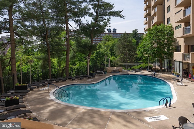 1101 S Arlington Ridge Rd Unit 1107, Arlington, VA 22202 - community pool with fence, a patio area, and view of wooded area