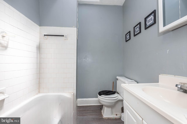 bathroom featuring vanity, baseboards, wood finished floors, and toilet