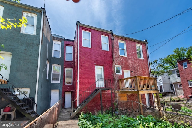 view of front of home featuring stairs, fence, and brick siding
