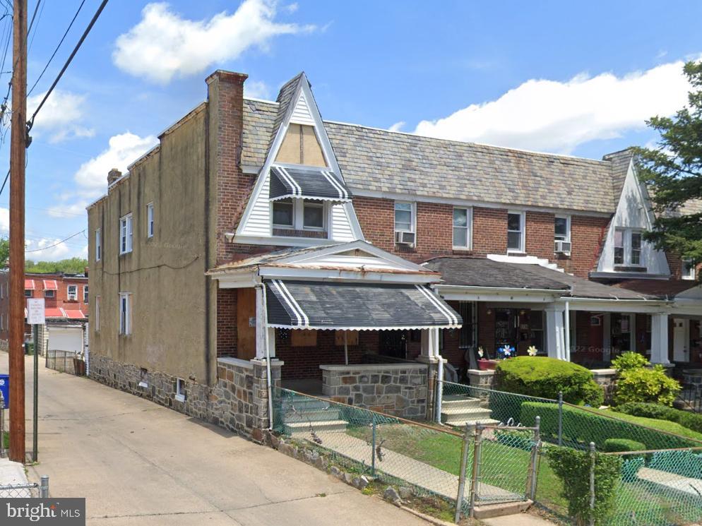 view of front of house featuring brick siding, a fenced front yard, and a gate