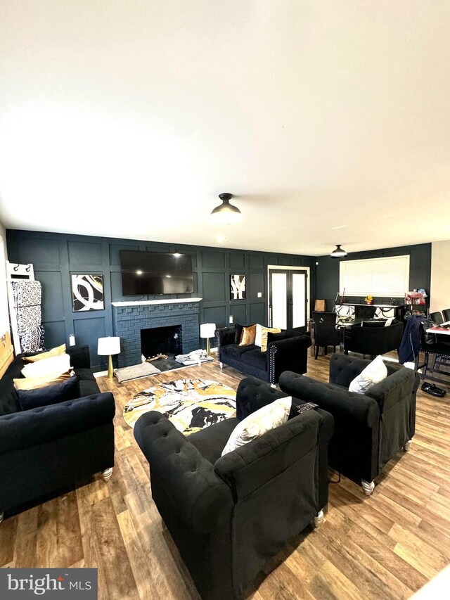 5902 Middleton Ct, Temple Hills, MD 20748 - living room featuring wood finished floors, a decorative wall, and a brick fireplace