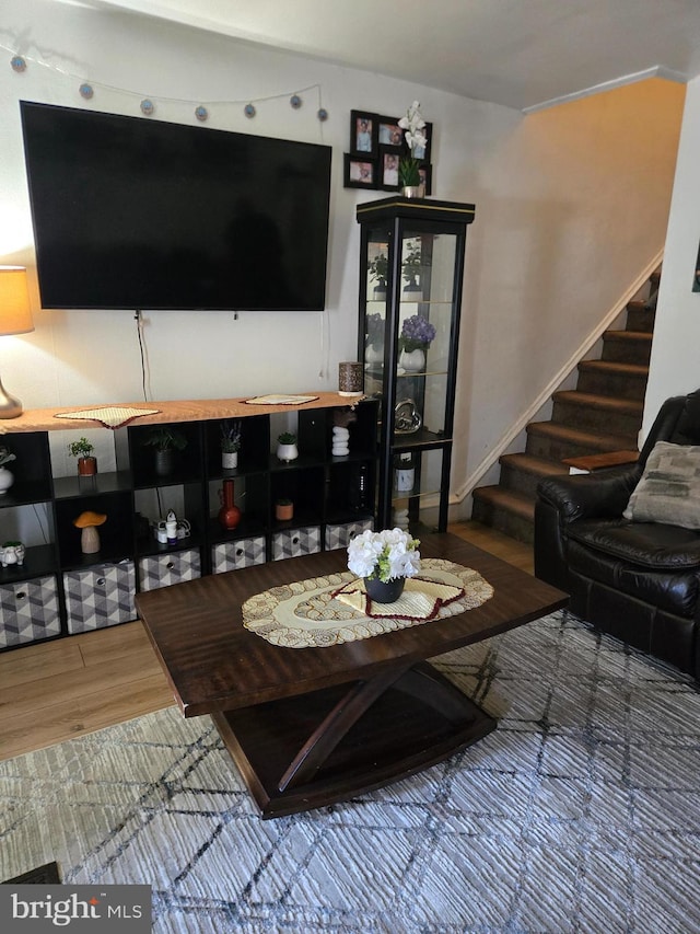 living area featuring wood finished floors and stairway