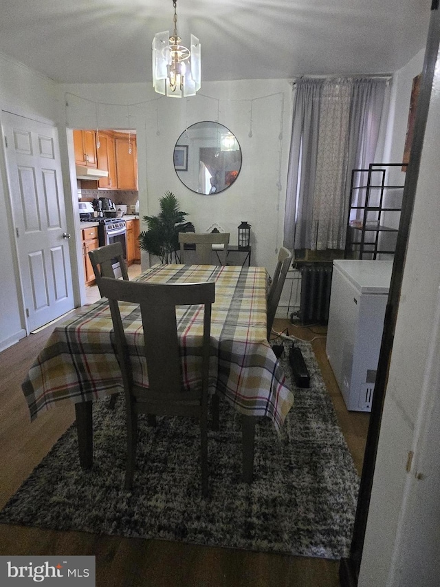 dining area featuring wood finished floors and a notable chandelier