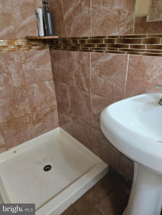 full bath featuring tile walls and a stall shower