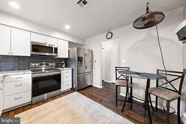 54 Dogwood Rd, Manahawkin, NJ 08050 - kitchen featuring stainless steel appliances, dark wood finished floors, white cabinetry, visible vents, and tasteful backsplash