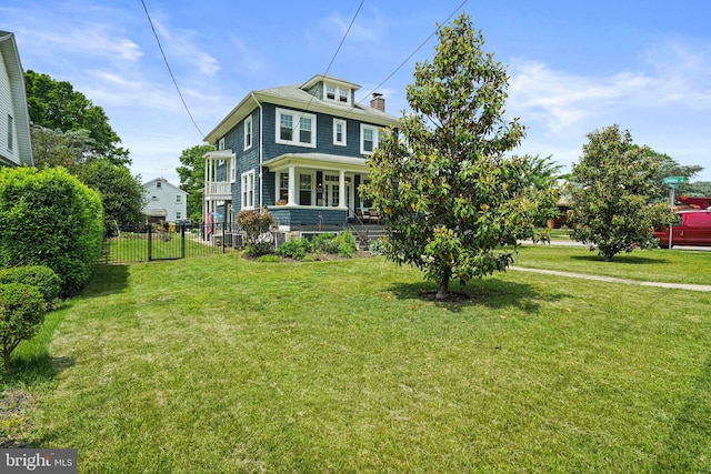 american foursquare style home featuring a chimney and covered porch