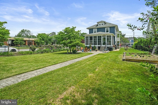 rear view of house featuring a garden, a sunroom, a patio area, and entry steps