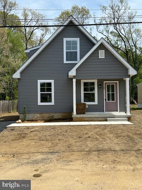 view of front of property featuring covered porch and fence