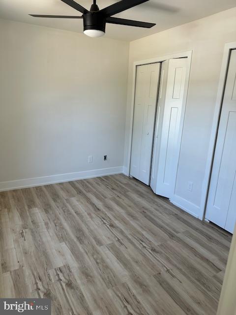 unfurnished bedroom featuring baseboards, ceiling fan, and wood finished floors