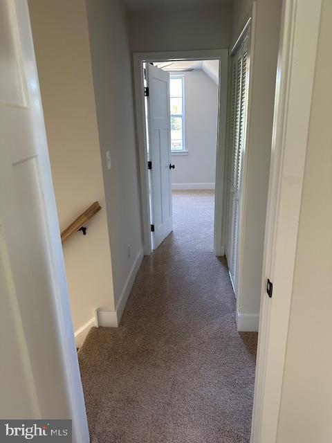 hallway with carpet flooring and baseboards