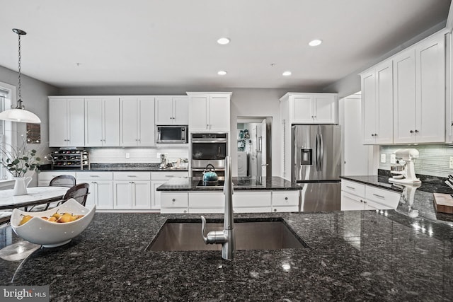 kitchen with recessed lighting, hanging light fixtures, white cabinetry, tasteful backsplash, and appliances with stainless steel finishes