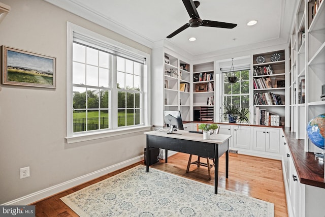 office space featuring baseboards, light wood-style floors, a healthy amount of sunlight, and ceiling fan