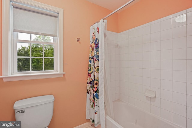 bathroom featuring toilet, baseboards, and shower / bath combination with curtain