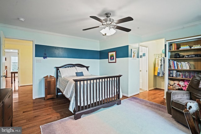 bedroom with crown molding, baseboards, and wood finished floors