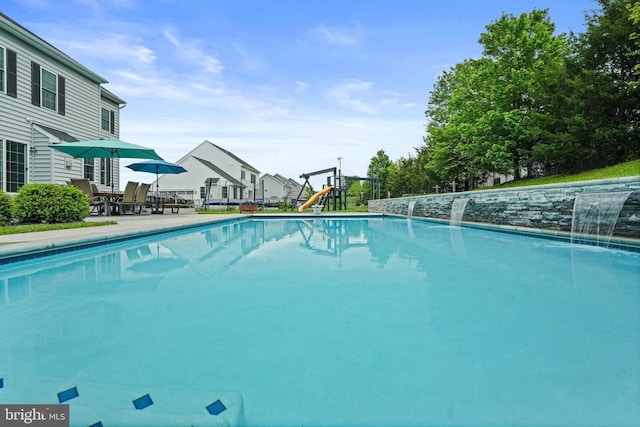 pool with playground community, a patio area, and a residential view