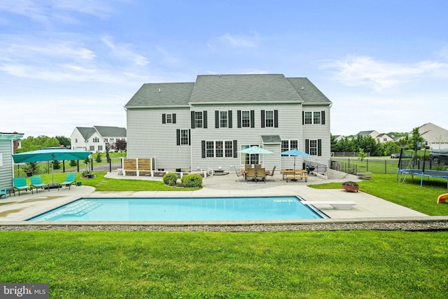 back of house featuring a yard, an outdoor pool, a patio area, a shingled roof, and a fenced backyard