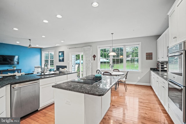 kitchen featuring recessed lighting, stainless steel appliances, open floor plan, and a sink