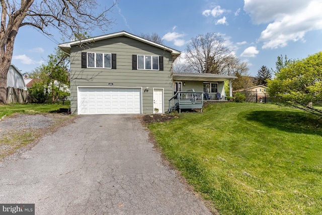 tri-level home featuring an attached garage, a front lawn, driveway, and covered porch