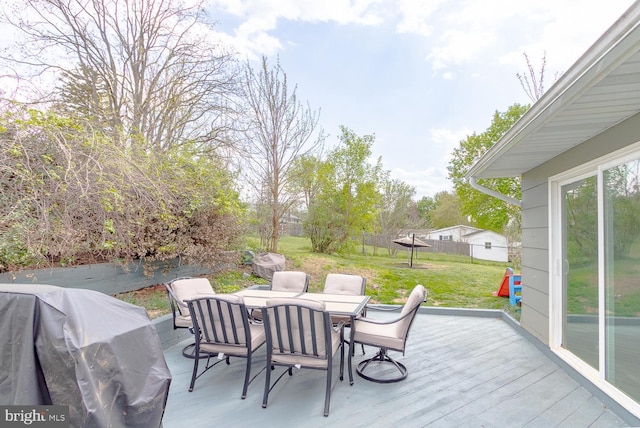 deck featuring a lawn, a fenced backyard, area for grilling, and outdoor dining space