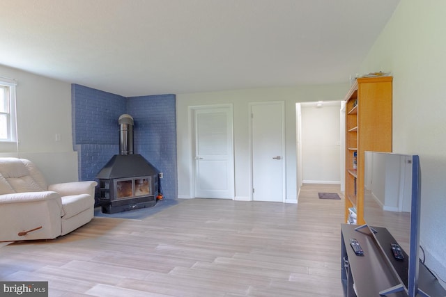 living room featuring light wood-type flooring and a wood stove