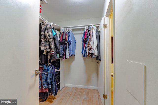 walk in closet with wood finished floors