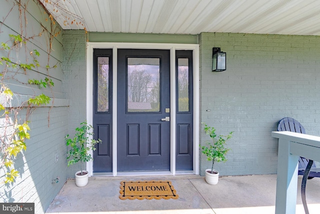 view of exterior entry featuring brick siding