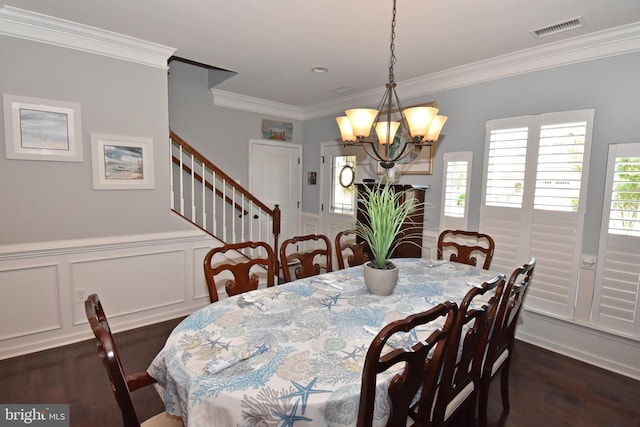 dining room featuring dark wood-style flooring, ornamental molding, an inviting chandelier, and visible vents